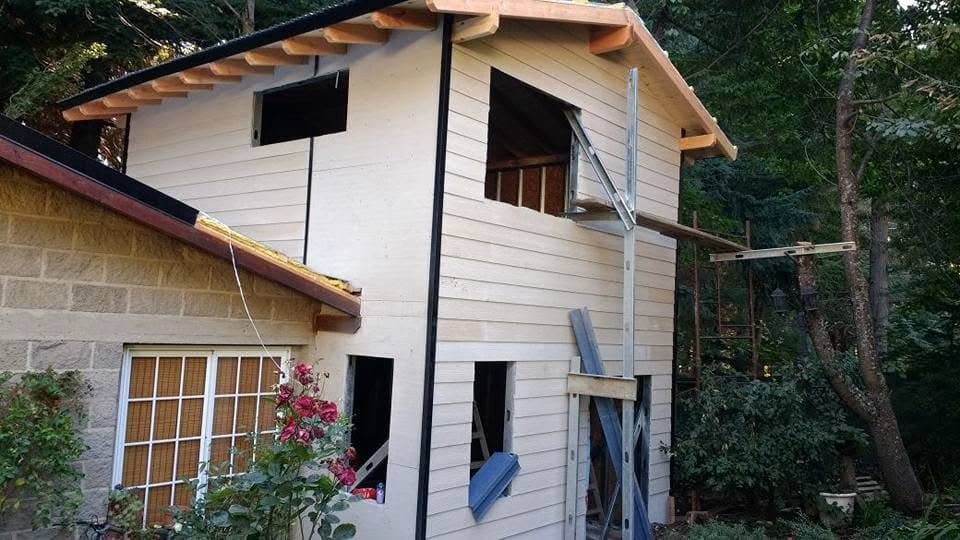 Vivienda de dos plantas con siding claro en el bosque