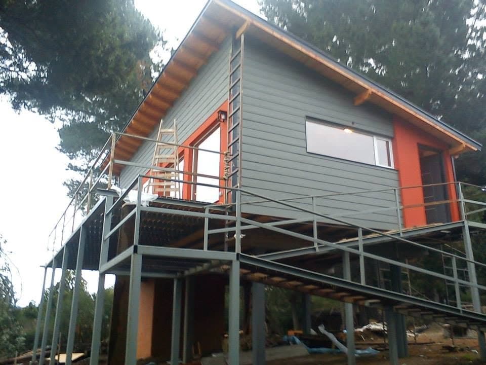 Casa de construcción en seco elevada con deck en zona de bosque