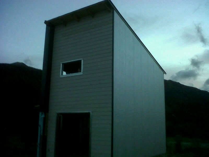 Casa de dos plantas terminada con siding oscuro en valle de montaña